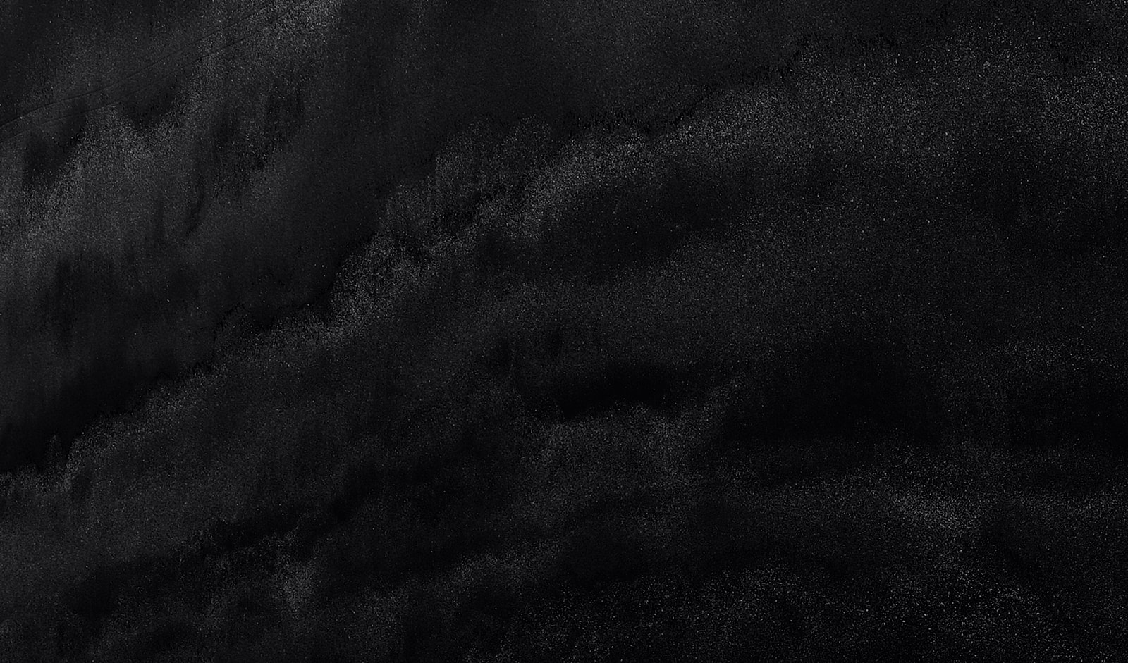 Abstract black texture with subtle gradients.