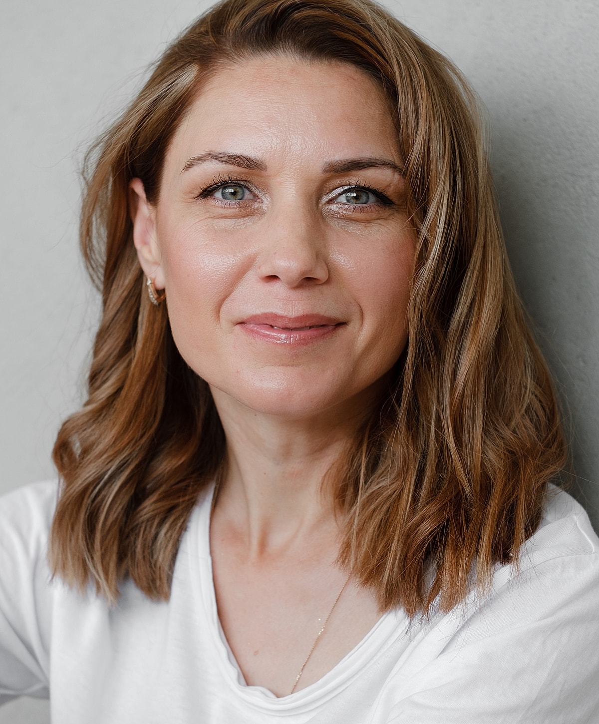 Woman with shoulder-length hair smiling at camera.