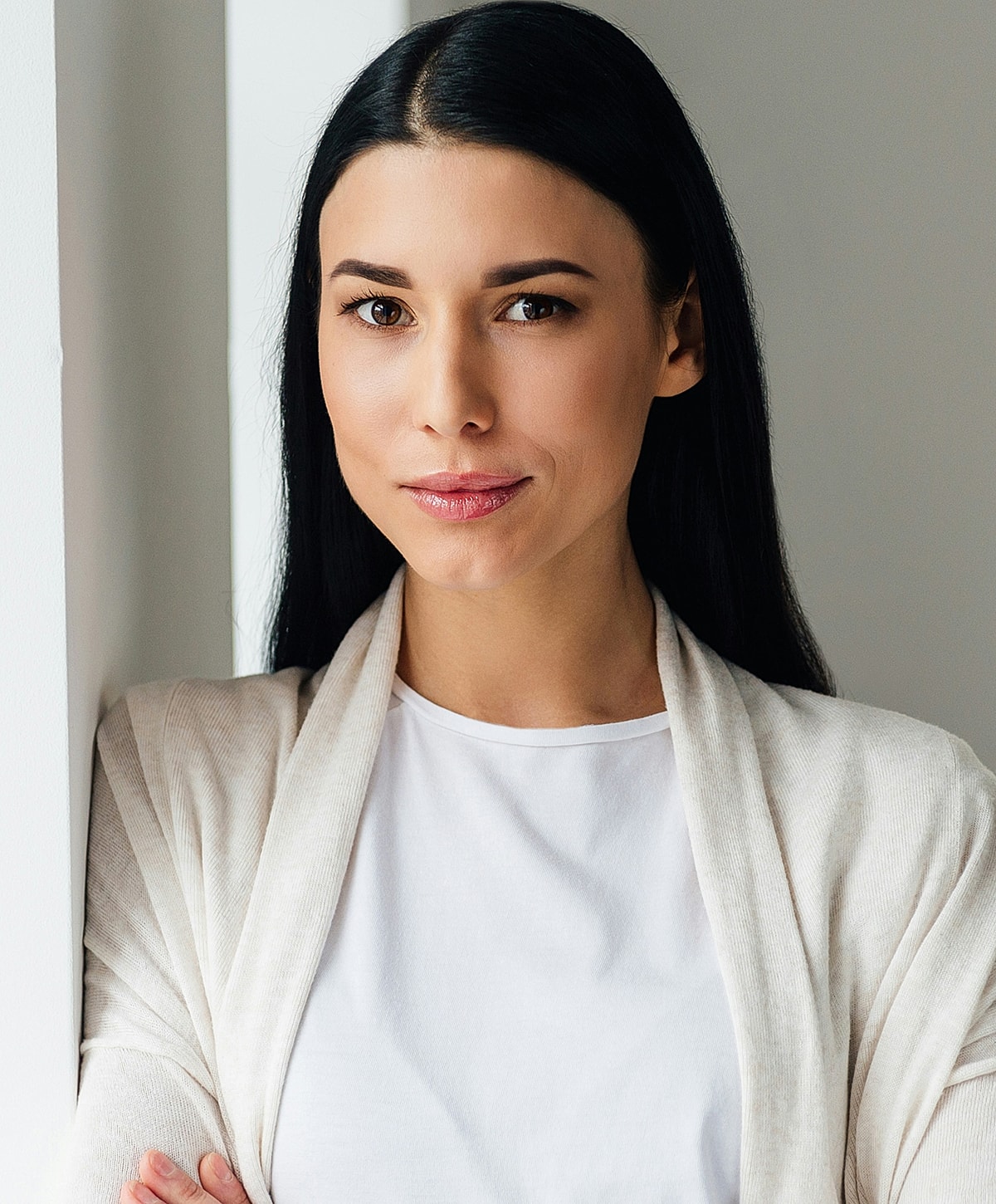 Woman with long hair, neutral expression, stylish attire.