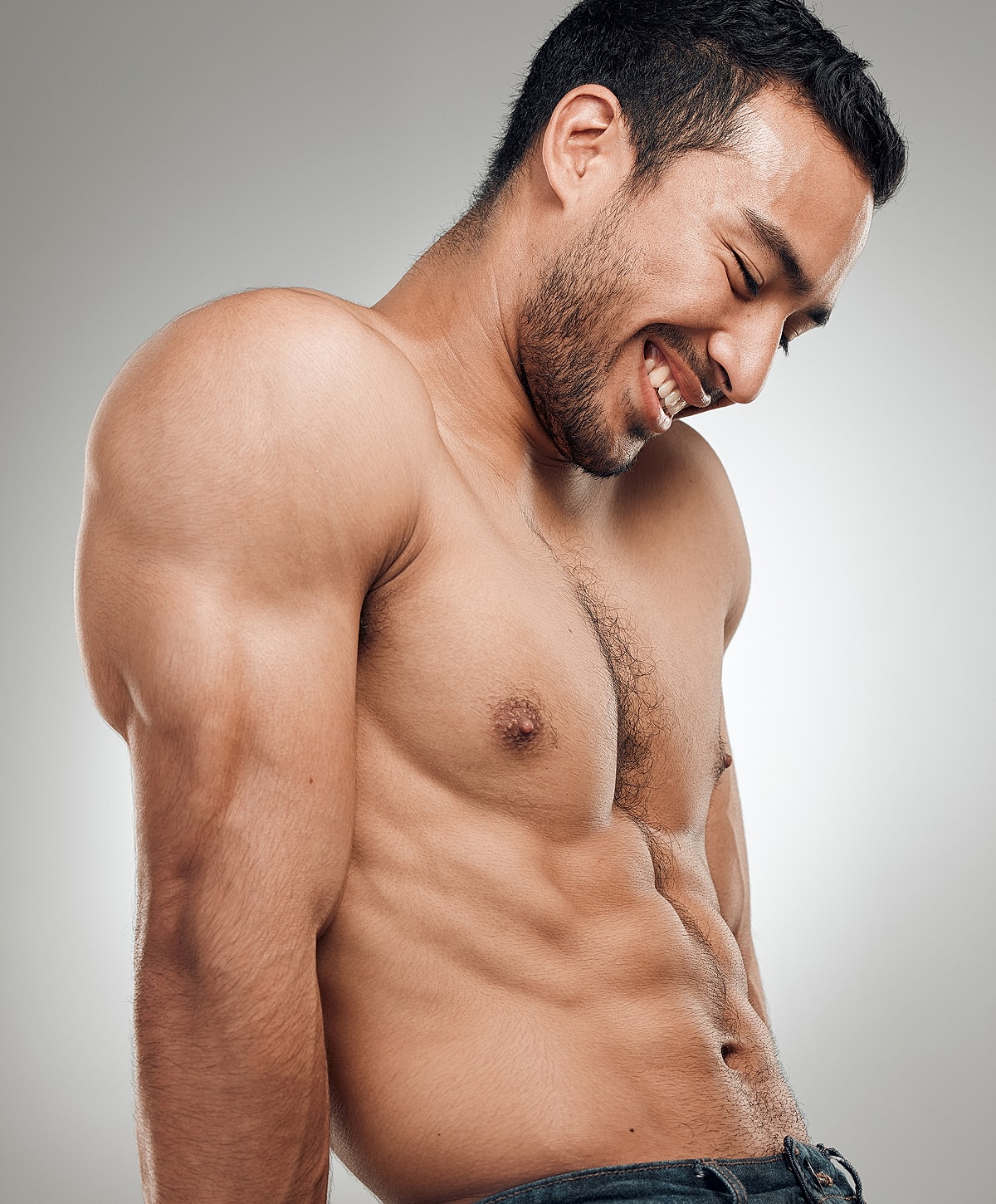 Smiling man with defined muscular physique.