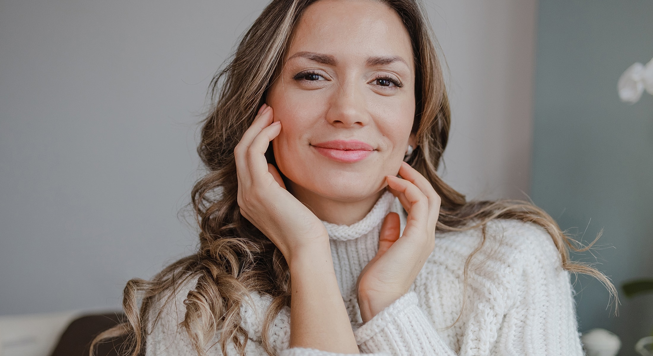 Woman smiling with hands on her face.