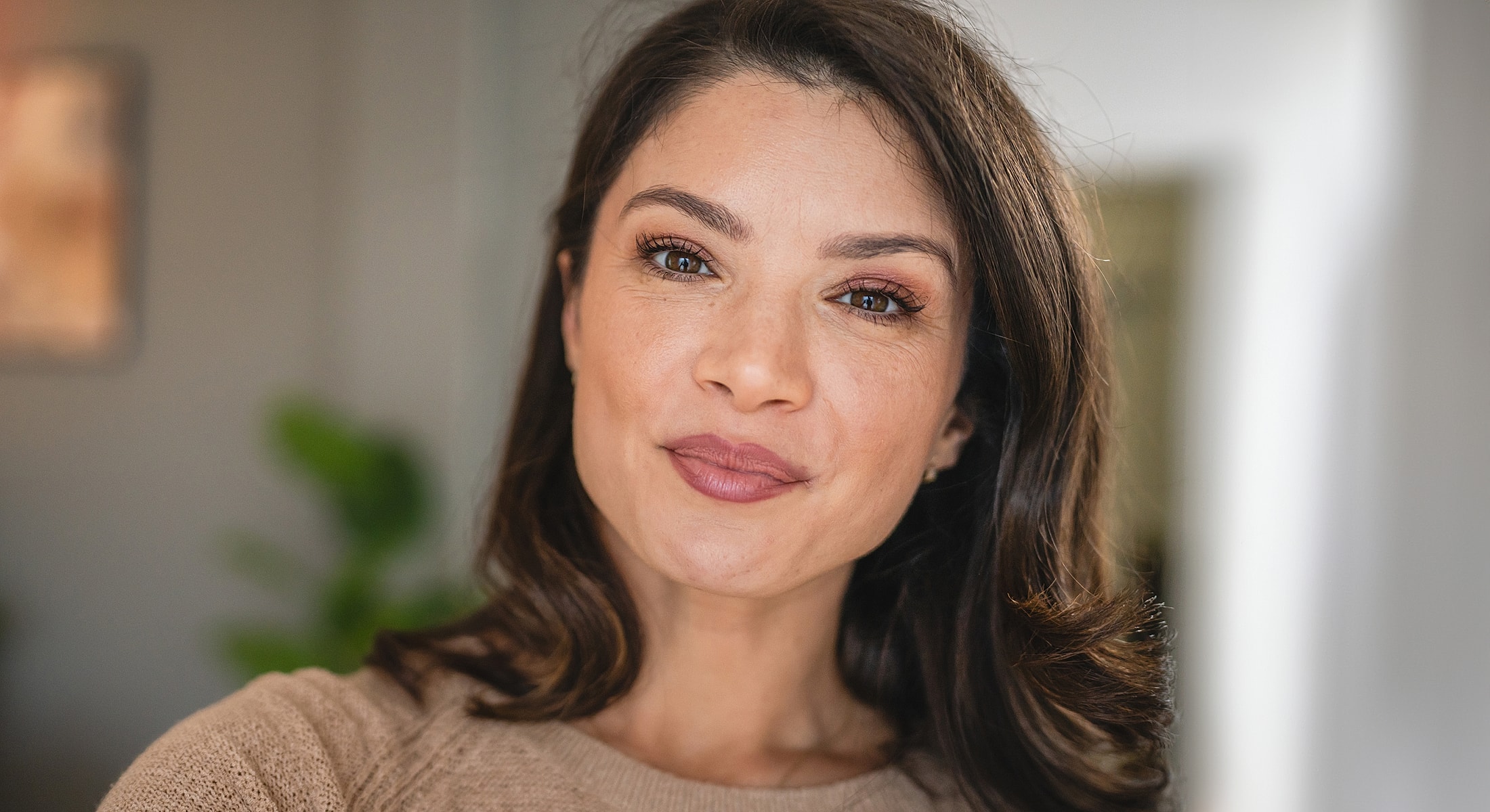 Woman smiling warmly in soft indoor lighting.