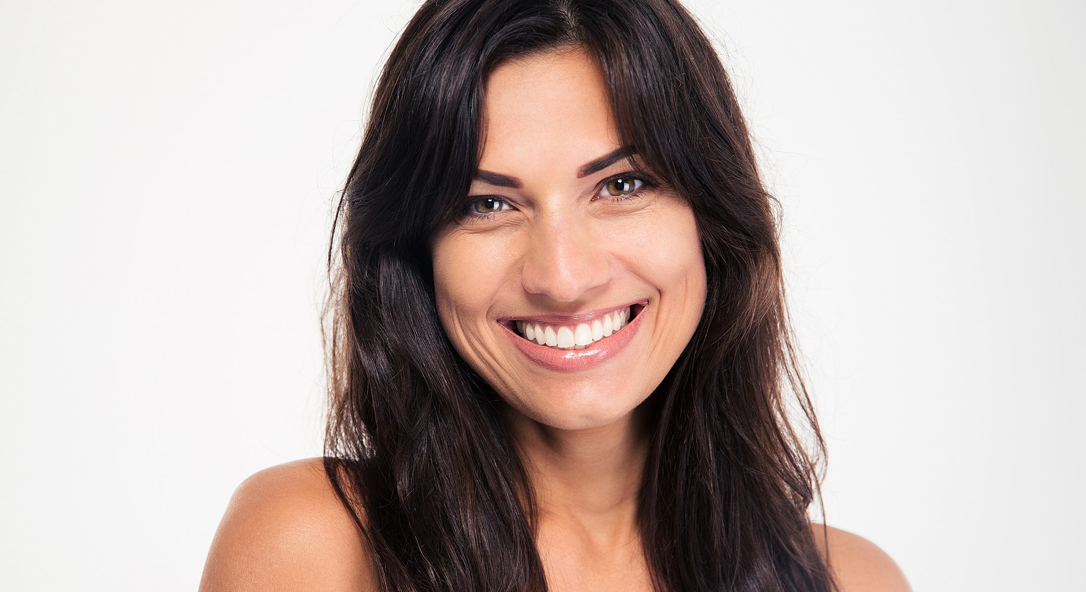 Smiling woman with long dark hair on white background