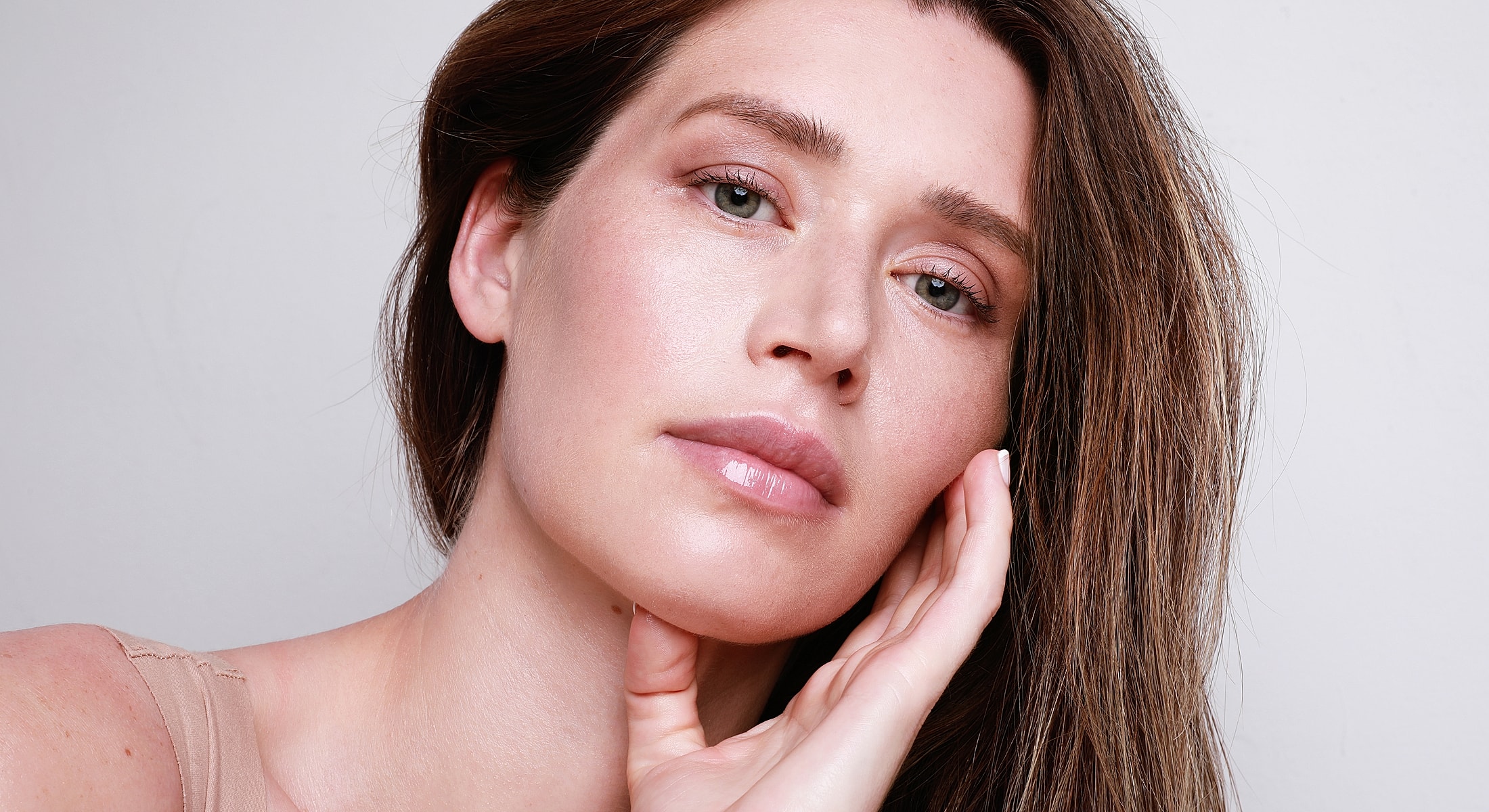 Close-up of woman touching her face.